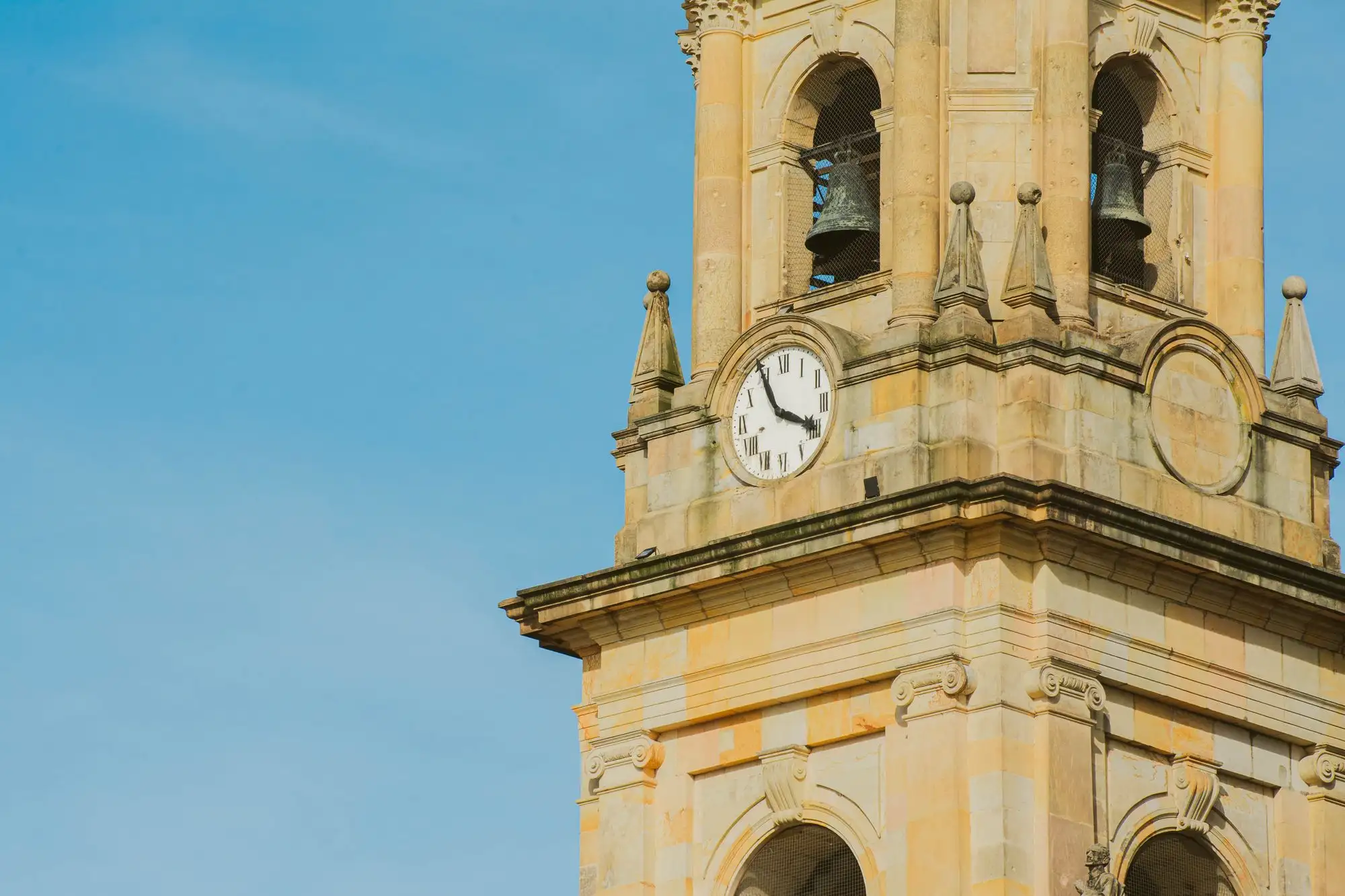 The clock tower of a church in Bogotá against a blue sky