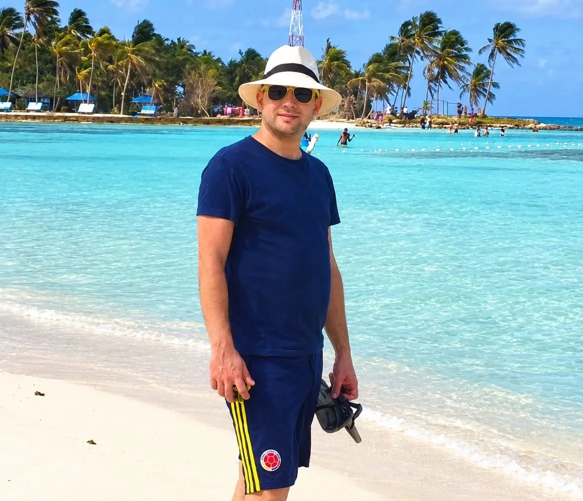 Gianluca Orlandi, autor de colombia.io, a la orilla del mar con sombrero y pantaloneta de la Selección Colombia