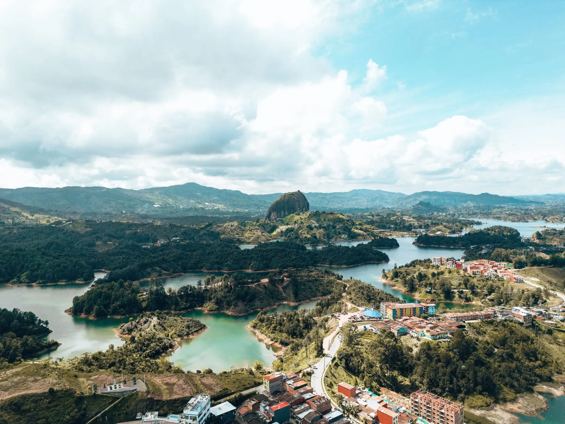 Vista aérea del embalse de Guatapé con sus islas verdes, el pueblo y la Piedra del Peñol al fondo
