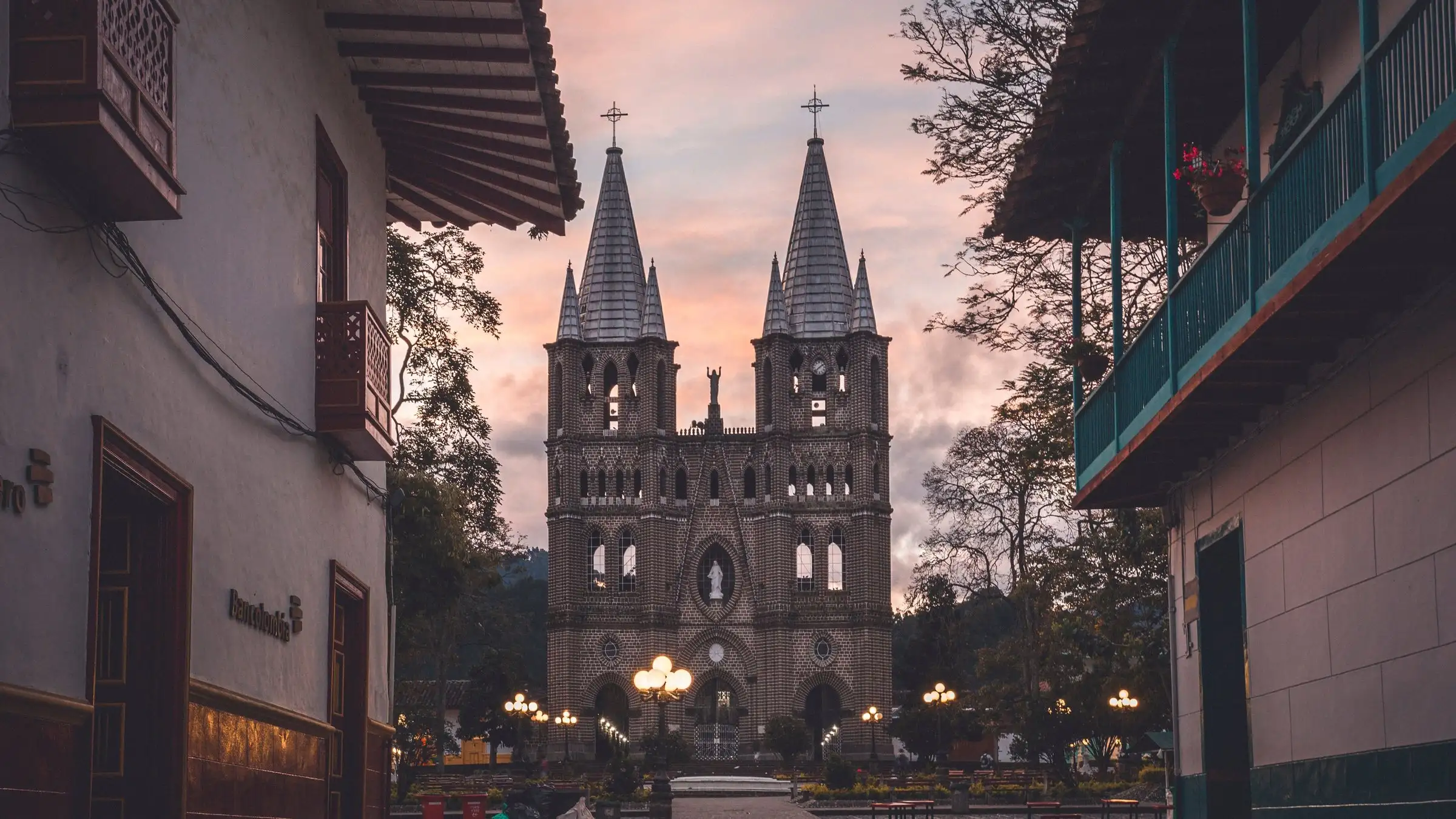 Jardín's neo-Gothic basilica at sunset, seen from a street lined with wooden-balconied houses