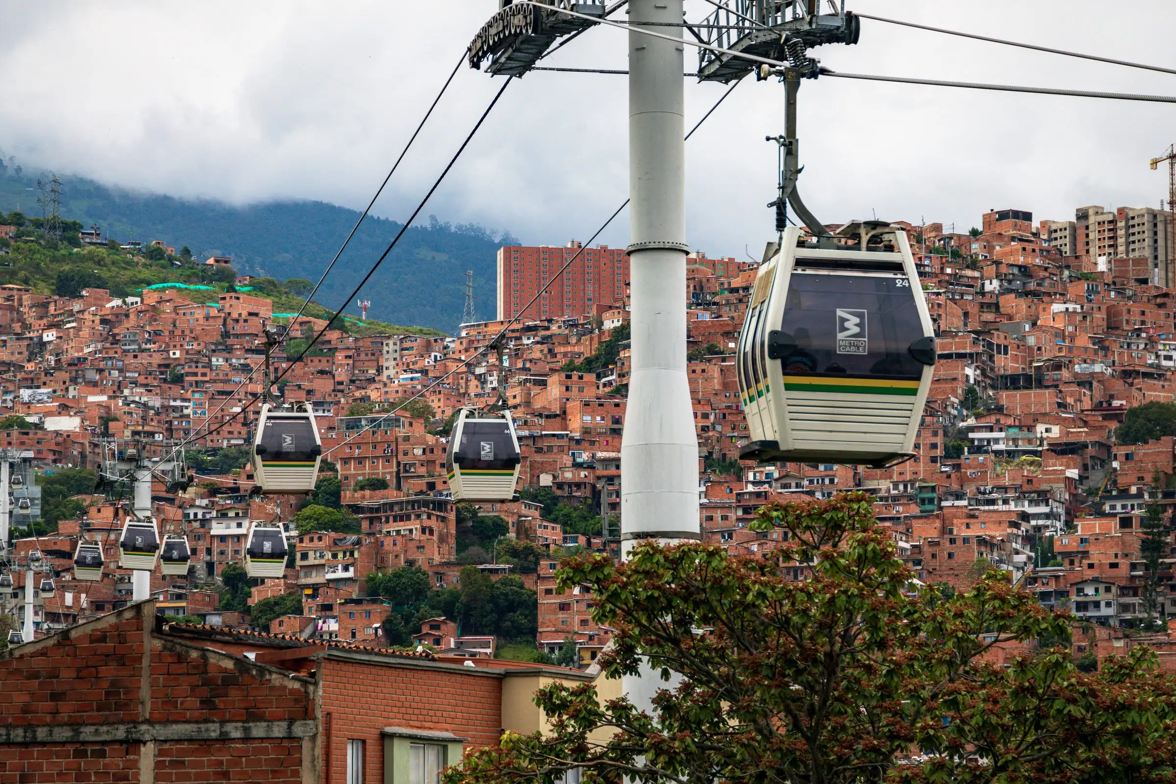 Metrocable cars passing over red-brick neighbourhoods on Medellín's hillsides