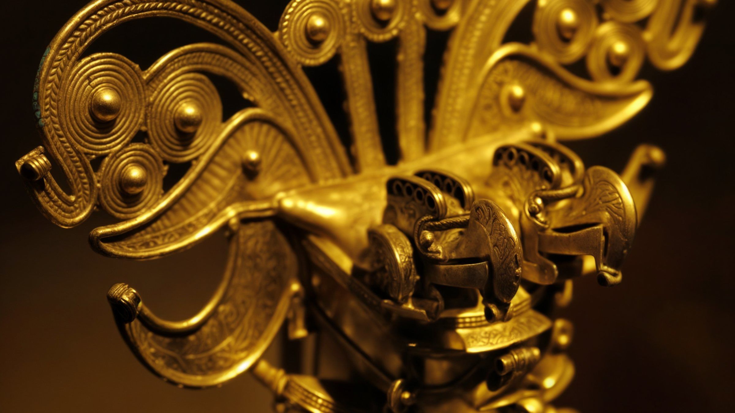 Dettaglio di un ornamento d'oro precolombiano di stile tairona, illuminato su fondo scuro