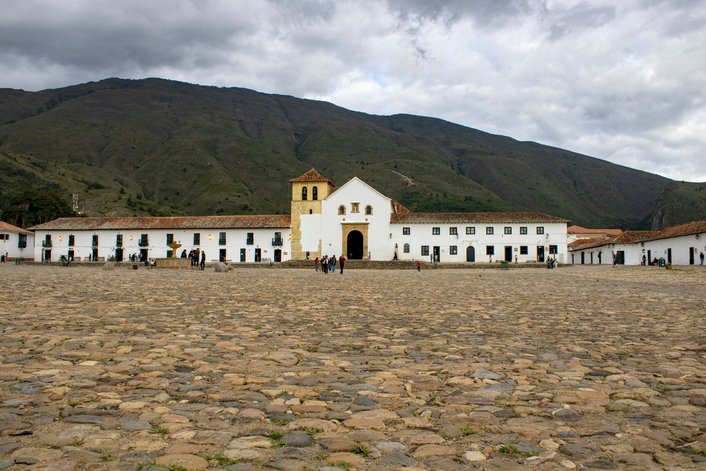Villa de Leyva's cobbled Plaza Mayor with the white church and mountains in the background