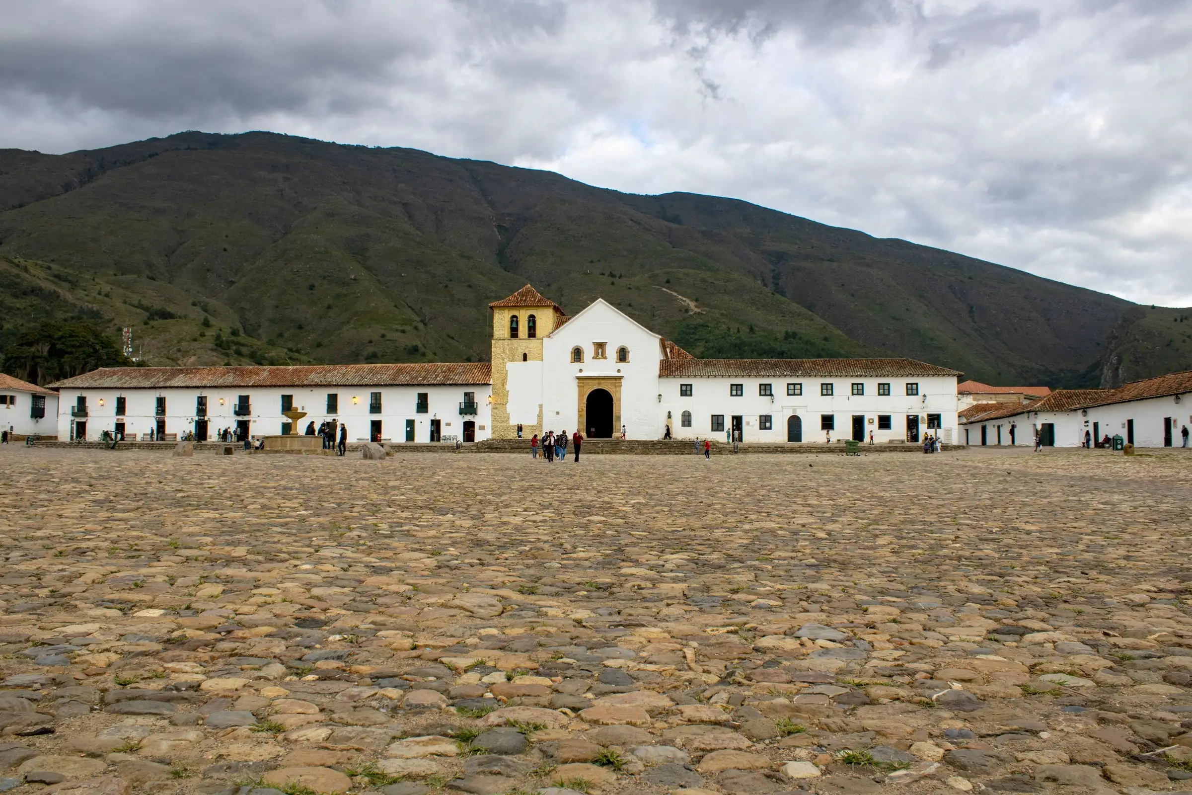 La Plaza Mayor empedrada de Villa de Leyva con la iglesia blanca y las montañas al fondo