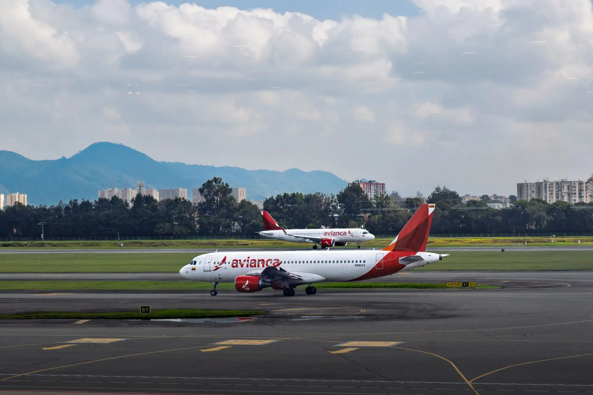 An Avianca plane on the runway at Bogotá's El Dorado airport with mountains in the background